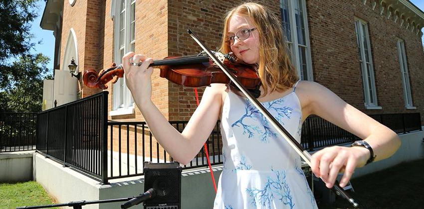 Student playing Violin in front of Honors